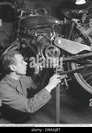 Dans les années 1940 Un intérieur d'un atelier de vélos et de cyclomoteurs où travaille la star du patinage Åke Seyffarth et est vu avec une moto qui est en réparation ou en service. Le moteur est fabriqué par la société allemande Sachs. Åke Seyffarth, athlète suédois et olympien 1919-1998 qui a remporté une médaille d'argent et une médaille d'or en 1948 Suède février 1940 Kristoffersson ref 69-5 Banque D'Images