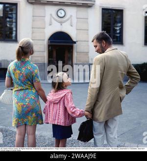 parents des années 1960. Une mère et un père accompagnent leur fille lors de son premier jour d'école. 1969 Banque D'Images