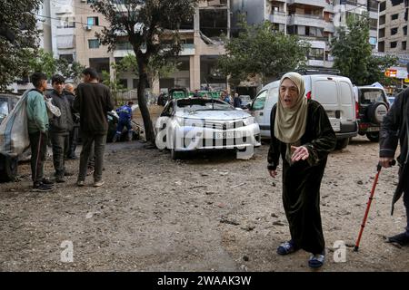 Beyrouth, Liban. 03 janvier 2024. Une libanaise âgée marche devant le bureau détruit du Hamas qui a été attaqué par Israël le 02 janvier, tuant Saleh al-Arouri et six autres personnes dans la banlieue sud de Beyrouth. Crédit : Marwan Naamnai/dpa/Alamy Live News Banque D'Images