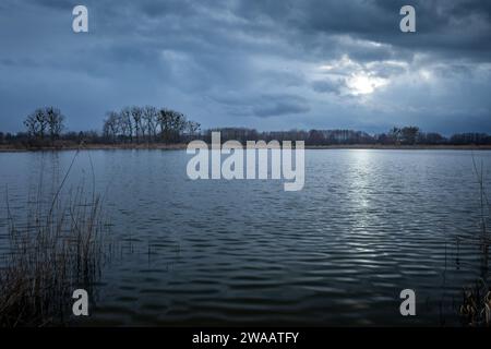 Nuages sombres du soir avec lueur de la lune sur un lac calme, l'est de la Pologne Banque D'Images