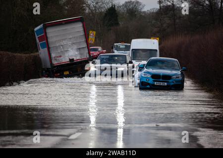 LEOMINSTER, ROYAUME-UNI - 03 JANVIER 2024 : les navetteurs passent devant deux voitures abondonées et un camion dans les eaux de crue à la périphérie de Leominster ouest sur l'A44 en direction de Monkland. Crédit : Jim Wood/Alamy Live News Banque D'Images