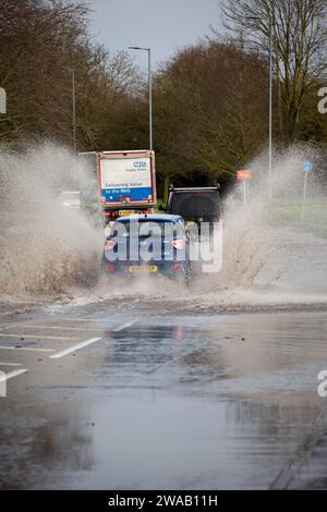 LEOMINSTER, ROYAUME-UNI - 03 JANVIER 2024 : les navetteurs traversent les inondations sur la Worcester Road dans la ville de Leominster. Crédit : Jim Wood/Alamy Live News Banque D'Images