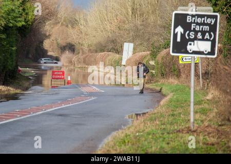 LEOMINSTER, ROYAUME-UNI - 03 JANVIER 2024 : une voiture est vue abandonnée dans les eaux de crue à Broadward à la périphérie de Leominster sud sur l'ancienne Hereford Road (B4361). Crédit : Jim Wood/Alamy Live News Banque D'Images