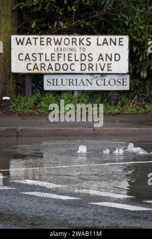 LEOMINSTER, ROYAUME-UNI - 03 JANVIER 2024 : de l'eau jaillit d'un drain routier causant des inondations sur la Worcester Road dans la ville de Leominster. Crédit : Jim Wood/Alamy Live News Banque D'Images