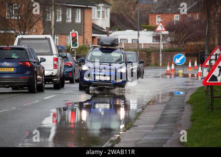 LEOMINSTER, ROYAUME-UNI - 03 JANVIER 2024 : les navetteurs traversent les inondations sur la Worcester Road dans la ville de Leominster. Crédit : Jim Wood/Alamy Live News Banque D'Images