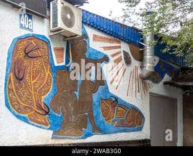 Sgraffiti murale représentant la famille kazakhe et le Soleil, artiste : Sidorkin Evgeniy, 1961, Almaty Kazakhstan Banque D'Images