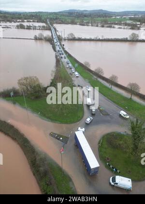 Hereford, Herefordshire, Royaume-Uni – mercredi 3 janvier 2024 – Météo britannique – vue aérienne par drone des champs inondés et des routes à la périphérie de Hereford le long de la route A4103 vers Worcester. Cette inondation vient de la rivière Lugg avec la route locale de Sutton St Nicholas fermée à ce rond-point en raison des inondations. Photo Steven May / Alamy Live News Banque D'Images