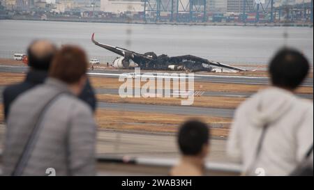 Tokyo, Japon. 03 janvier 2024. Les gens regardent l'Airbus A350 brûlé de Japan Airlines (JAL) après une collision avec un avion MA722 Mizunagi (Bombardier DHC-8-300) de la Garde côtière japonaise à l'aéroport international de Tokyo (aéroport Haneda) à Tokyo, Japon, le mercredi 3 janvier 2024. Photo de Keizo Mori/UPI crédit : UPI/Alamy Live News Banque D'Images