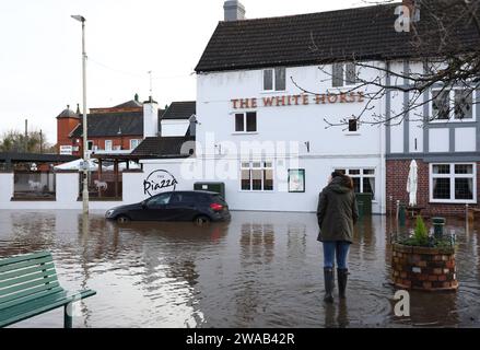 Quorn, Leicestershire, Royaume-Uni. 3 janvier 2024. Météo britannique. Une femme regarde un pub assis dans l'eau d'inondation. De fortes pluies et des vents ont frappé de larges pans du Royaume-Uni après le petit mais puissant coup de tempête Henk. Crédit Darren Staples/Alamy Live News. Banque D'Images