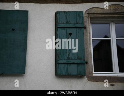 Fenêtre en bois alsacienne typique avec volets sur un mur patiné à Dambach-la-ville, France. Banque D'Images