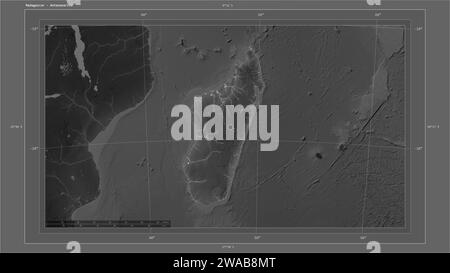 Madagascar mis en évidence sur une carte d'altitude en niveaux de gris avec la carte des lacs et des rivières avec le point de la capitale du pays, la grille cartographique, l'échelle de distance et Banque D'Images