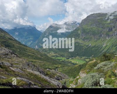 Vue générale sur la vallée vers le port de croisière à Geiranger, Norvège depuis la route 63. Eagle Road est visible à l'extrême distance. Banque D'Images