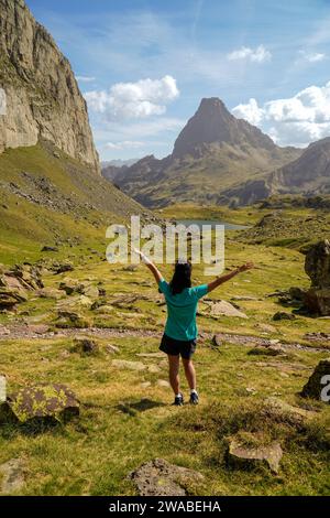 Photo verticale vue arrière d'une jeune femme sportive levant les bras dans la montagne Banque D'Images