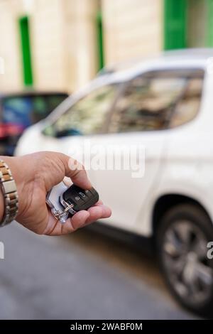 Photo verticale recadrée de la main d'une personne ouvrant une voiture avec télécommande Banque D'Images