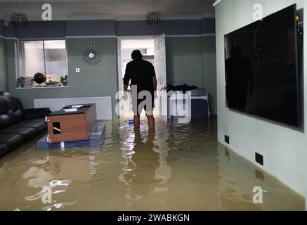 Loughborough, Leicestershire, Royaume-Uni. 3 janvier 2024. Météo britannique. Un homme traverse sa maison inondée sur Belton Road. De fortes pluies ont frappé une grande partie du Royaume-Uni alors que le petit mais puissant Storm Henk a frappé. Crédit Darren Staples/Alamy Live News. Banque D'Images