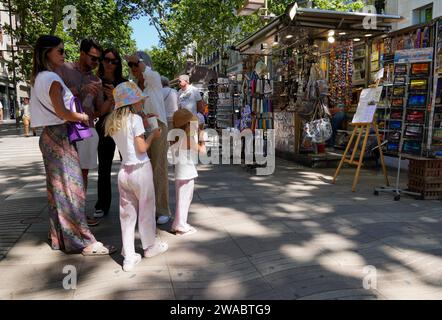 Barcelone, Espagne - 26 mai 2022 : un groupe d'adultes arrête leur promenade le long des Ramblas de Barcelone pour vérifier le smartphone et s'assurer qu'il est bien Banque D'Images