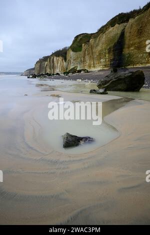 Marée basse avec du sable et des rochers sur une plage avec des falaises de craie Banque D'Images