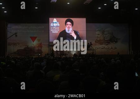 Beyrouth, Liban. 03 janvier 2024. Hassan Nasrallah, secrétaire du Hezbollah pro-iranien, s'adresse à ses partisans dans un discours télévisé à l'occasion du 4e anniversaire de l'assassinat d'Abu Mahdi al-Mohandes, chef adjoint de la milice irakienne Hashd al-Shaabi, et du commandant de la Force Qods iranienne Qasem Soleiman dans la banlieue sud de Beyrouth. Crédit : Marwan Naamnai/dpa/Alamy Live News Banque D'Images