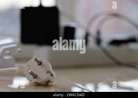 Cartes d'alimentation surchargées. Multiprises avec différentes prises électriques sur plancher blanc. Concept de risque danger courant surchargé électrique Banque D'Images