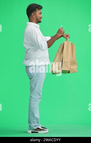 Un homme, sur fond vert, avec un sac, ondulant, profil Banque D'Images