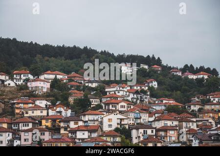 Les toits en terre cuite de la ville de montagne de Kruševo - Krushevo - en Macédoine du Nord. Une vue lointaine à travers les maisons sur la colline. Banque D'Images