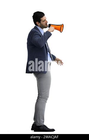 Un homme dans un costume de bureau sur un fond blanc parle dans un mégaphone, de profil Banque D'Images