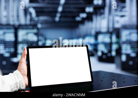 Gros plan d'une maquette de tablette utilisée par un technicien dans un hub serveur, offrant une puissance de calcul immense, capable de traiter et de stocker de grandes quantités de données et de contrôler les ressources réseau Banque D'Images