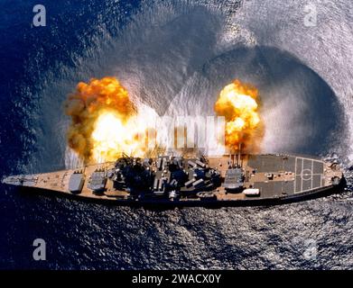 L’USS Iowa (BB-61) tire sur une largeur de ses neuf canons 16″/50 et six canons 5″/38 lors d’un exercice sur cible près de Vieques Island, Porto Rico. Notez les effets de commotion cérébrale sur la surface de l'eau, et les canons de canon de 16 pouces dans des degrés variables de recul. 1984 Banque D'Images