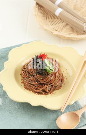 Nouille coréenne épicée Soba Bibim Guksu avec flocons de piment, concombre et garniture de graines de sésame Banque D'Images