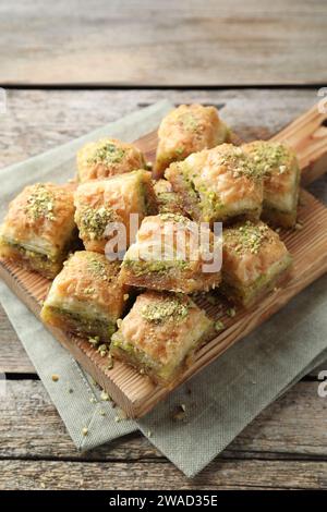 Délicieux baklava frais avec des noix hachées sur la table en bois. Bonbons orientaux Banque D'Images