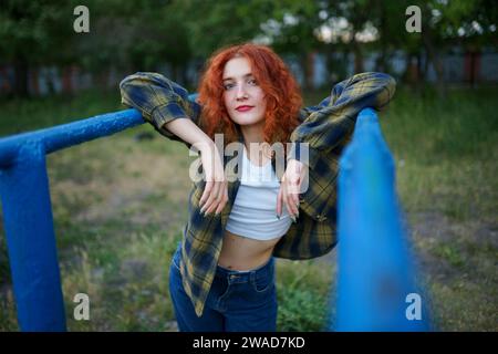 Femme rousse posant au terrain de jeu Banque D'Images