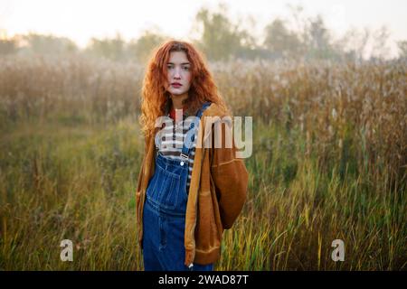 Portrait de jeune femme debout dans le champ à l'aube Banque D'Images
