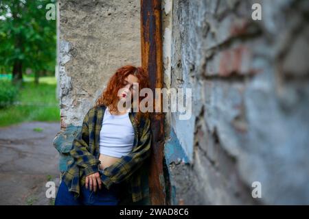 Femme fatiguée avec les yeux fermés appuyé sur le mur du bâtiment Banque D'Images