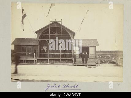 Bâtiment du club de l'IJsclub Utrecht, 1888 photographie le bâtiment du club de l'IJsclub Utrecht avec un drapeau brandissant. Devant le bâtiment, il y a un certain nombre d'hommes avec chapeau melon et long pardessus. Avec légende : IJsclub Utrecht. Papier néerlandais. tirage photographique à l'albumine sur support Banque D'Images