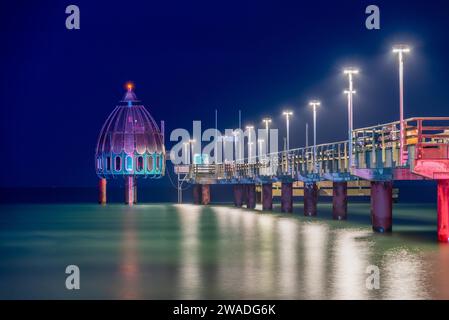 Télécabine de plongée et longue jetée éclairée dans la mer la nuit, l'eau calme reflète les lumières, Zingst, Mecklenburg-Vorpommern, Allemagne Banque D'Images