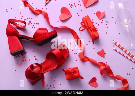 Composition avec des chaussures féminines rouges, des cadeaux et un décor pour la célébration de la Saint-Valentin sur fond de couleur Banque D'Images