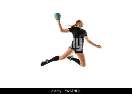 Femme caucasienne affûtant ses compétences de handball, montrant la précision dans la manipulation de balle sur fond de studio blanc propre. Concept de sport professionnel Banque D'Images