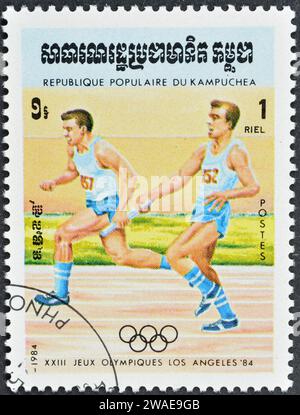 Timbre-poste annulé imprimé par le Cambodge, qui montre la course de relais, la promotion des Jeux olympiques d'été à Los Angeles, vers 1984. Banque D'Images