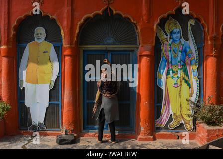 Nilam Singh, une résidente de RAM Janmabhoomi Path, réagit à la caméra en ouvrant la porte du temple où les découpes du Premier ministre indien Narendra Modi et du seigneur hindou RAM peuvent être vues à Ayodhya. Ayodhya est une ville ancienne dans le nord de l'Inde qui a une grande importance religieuse et historique dans l'hindouisme, car elle est considérée comme le lieu de naissance du Seigneur Rama, une divinité vénérée dans la mythologie hindoue. En novembre 2019, la Cour suprême de l'Inde a rendu un jugement historique en faveur de la construction d'un temple hindou sur le site controversé d'Ayodhya. Banque D'Images