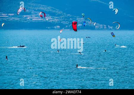 Kite surfeurs surfent sur la partie nord du lac de Garde en face de Torbole. Banque D'Images