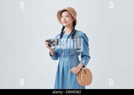 Belle femme d'été asiatique prenant la photo sur fond blanc Banque D'Images