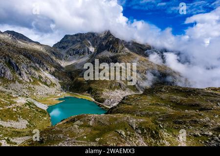 Vue aérienne sur le lac Lago di Cornisello Superiore à Brenta Dolomites, nuages se déplaçant de la vallée Sarca di Campiglio. Banque D'Images