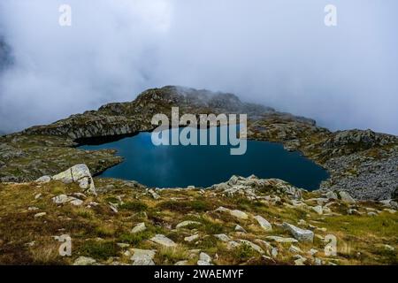 Vue aérienne sur le lac Lago Nero à Brenta Dolomites, nuages se déplaçant de la vallée Sarca di Campiglio. Banque D'Images