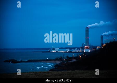 Une vue nocturne d'un grand site industriel, éclairé par les lampadaires environnants Banque D'Images