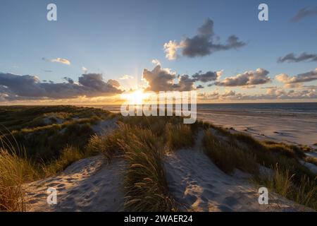 La belle vue sur le rivage sablonneux illuminé par les faisceaux du soleil levant Banque D'Images
