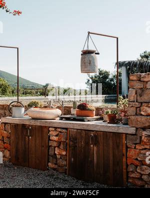 Un comptoir de cuisine extérieur avec une casserole suspendue dans un cadre rural Banque D'Images