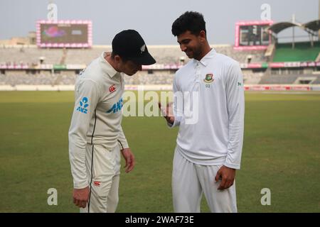 Le spinerMitchell Santner (G) regarde le doigt blessé du spiner bangladais Naeem Hasan (D) lors de la 2e journée test F Bangladesh-Nouvelle-Zélande Banque D'Images