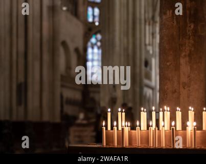 intérieur flou de l'église catholique avec bougie allumée ; fond abstrait Banque D'Images