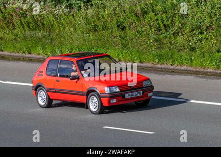 Années 1992 90 années 1990 Rouge Peugeot 205 GTI voiture Hatchback essence 1580 cc, 3 portes supermini, GL 1,6 1580cc GTI ; voyageant à grande vitesse sur l'autoroute M6 dans le Grand Manchester, Royaume-Uni Banque D'Images