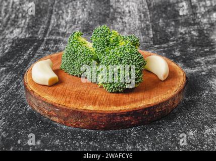 Brocoli vert et ail - image de nature morte du fond alimentaire. Support rond naturel en bois Banque D'Images